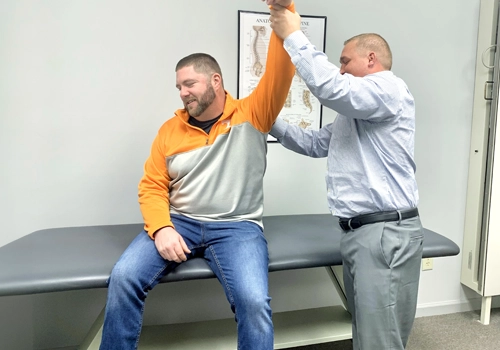 Chiropractor Knoxville TN Josh Rucker Examining Patients Arm