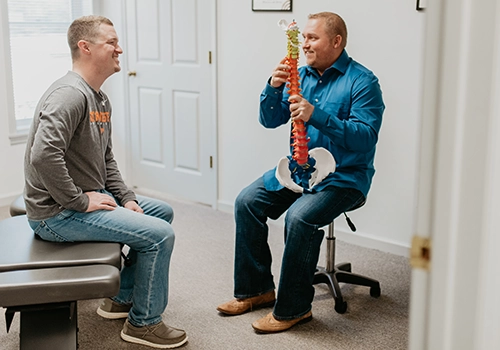 Chiropractor Knoxville TN Josh Rucker Pointing To Spine Model